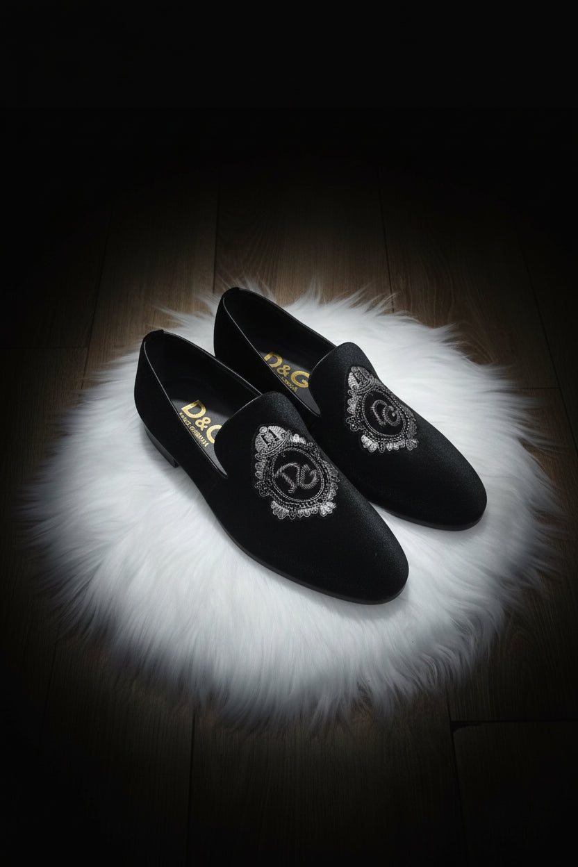 Black loafers with decorative elements on a white fur surface
