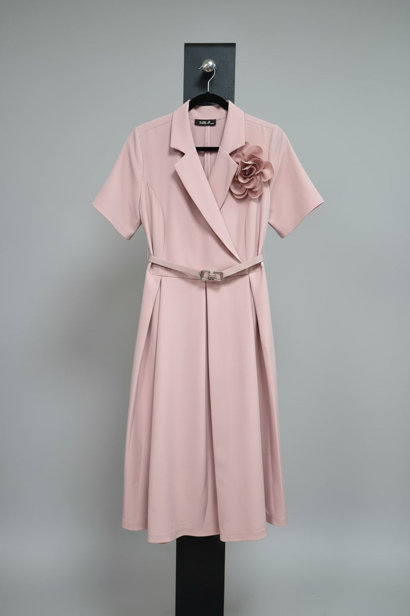 Pink trench coat with a floral accessory on a mannequin against a neutral background.