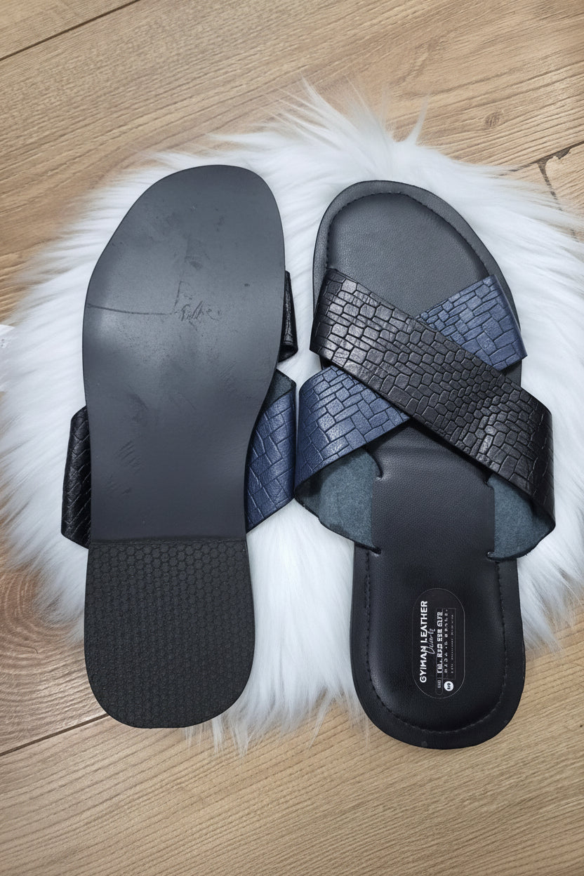 Black sandals with textured straps on a white fur rug