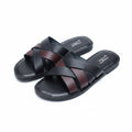 Pair of black sandals with brown straps on a white fluffy surface.