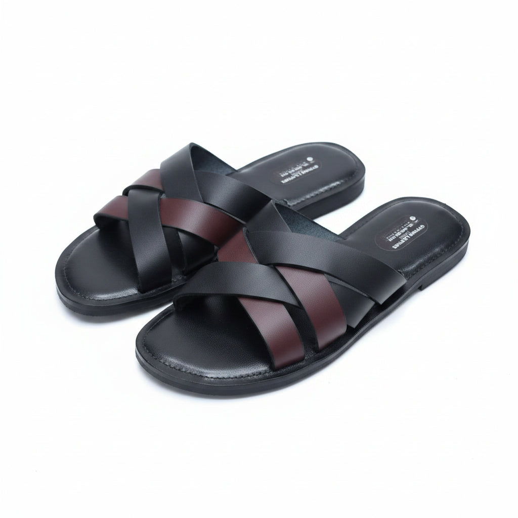 Pair of black sandals with brown straps on a white fluffy surface.
