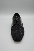 Black dress shoe with rhinestone embellishments on a white surface
